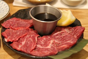 A picture of Wagyu Beef served on a tray with sauce.